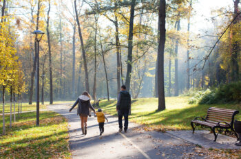A,Family,Walking,In,The,Park,In,Autumn