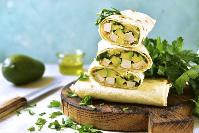 Chicken,Avocado,Burritos,On,A,Wooden,Cutting,Board,On,Light